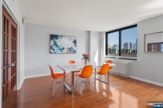 dining space featuring baseboards, visible vents, and wood finished floors