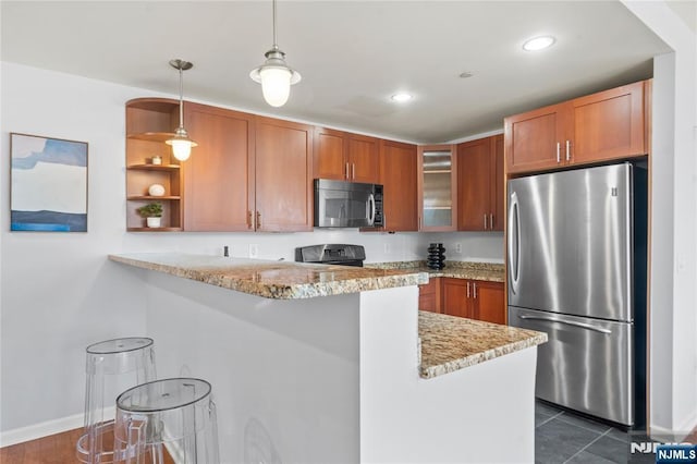 kitchen featuring brown cabinets, stainless steel appliances, glass insert cabinets, and a peninsula