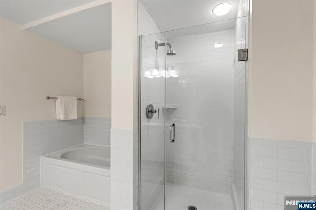 full bathroom with tile patterned flooring, a shower stall, and a garden tub