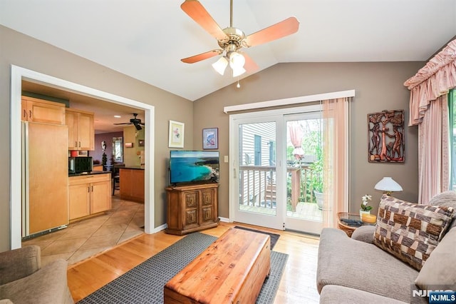 living area with a healthy amount of sunlight, ceiling fan, and lofted ceiling