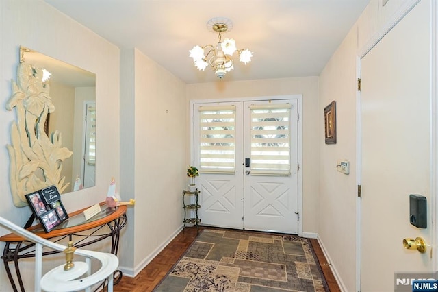 doorway to outside featuring baseboards, an inviting chandelier, and french doors