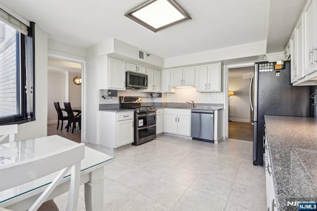 kitchen featuring a sink, appliances with stainless steel finishes, backsplash, and a wealth of natural light