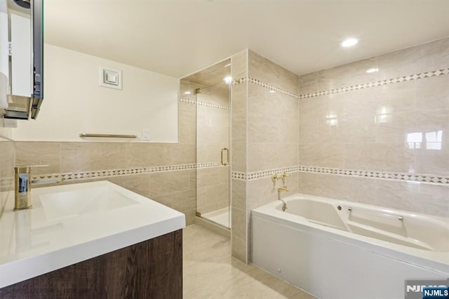 full bathroom featuring vanity, tile patterned floors, tile walls, a shower stall, and a garden tub