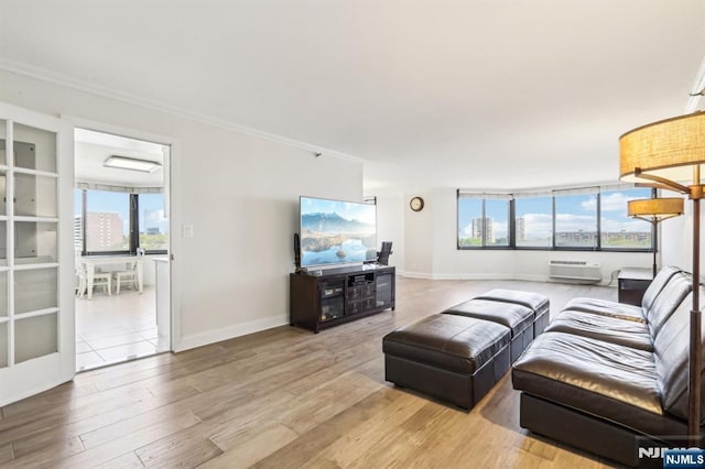 living area featuring crown molding, a wall mounted air conditioner, baseboards, and wood finished floors