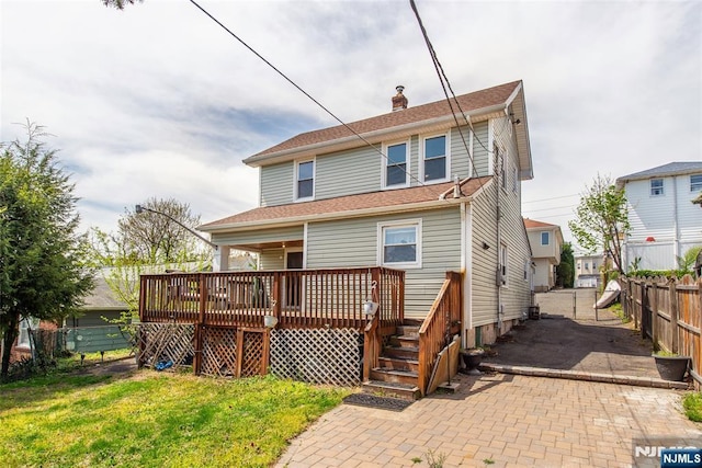 516 5th St, Carlstadt, NJ 07072 - back of property featuring fence, a chimney, a yard, and a deck