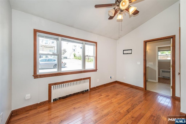 516 5th St, Carlstadt, NJ 07072 - empty room featuring lofted ceiling, radiator heating unit, and light wood-style flooring