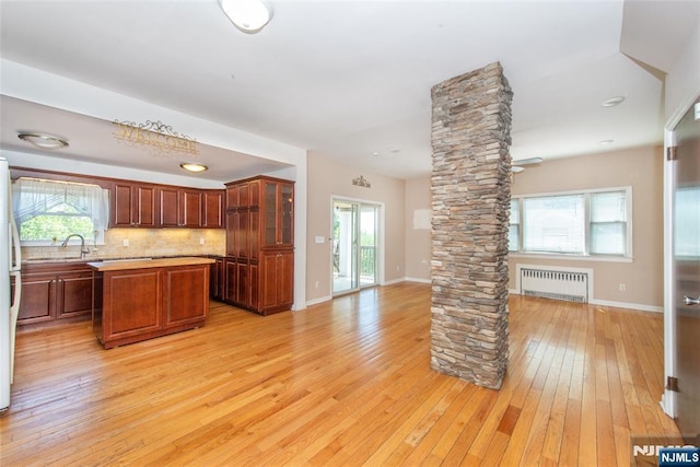 516 5th St, Carlstadt, NJ 07072 - kitchen with decorative columns, open floor plan, radiator heating unit, light countertops, and light wood-style flooring