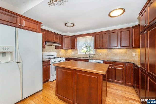 516 5th St, Carlstadt, NJ 07072 - kitchen with white appliances, light wood-style floors, under cabinet range hood, a sink, and backsplash