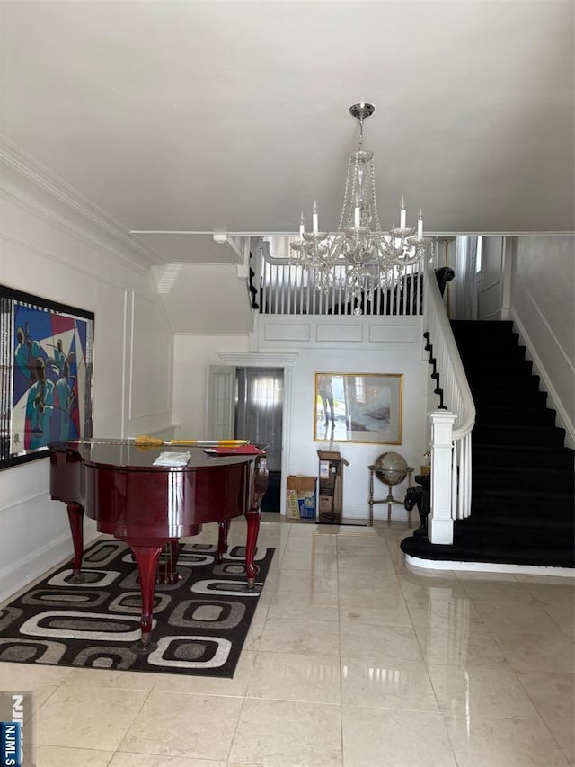 entrance foyer with a notable chandelier, ornamental molding, and stairway