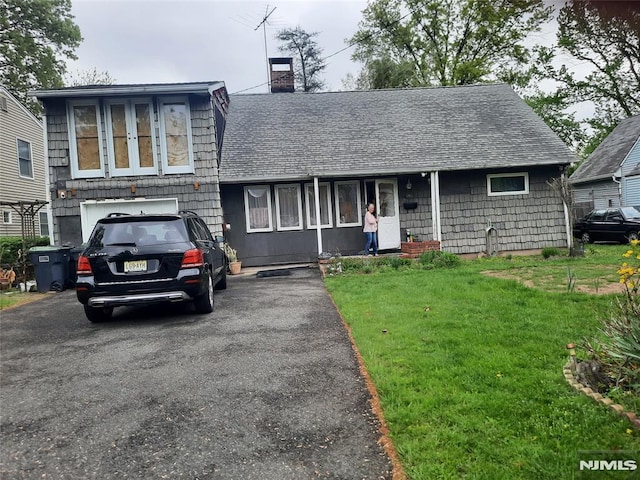 307 Phelps Ave, Bergenfield, NJ 07621 - split level home with a shingled roof, a front lawn, a chimney, and driveway