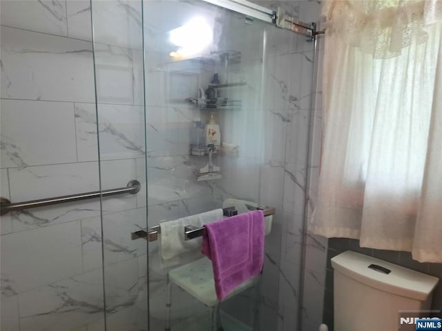307 Phelps Ave, Bergenfield, NJ 07621 - bathroom featuring toilet, a marble finish shower, and tile walls