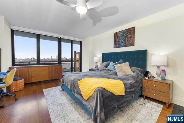 bedroom featuring baseboards, ceiling fan, wood finished floors, and access to exterior