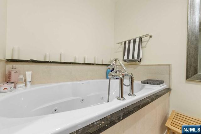 full bathroom with a whirlpool tub