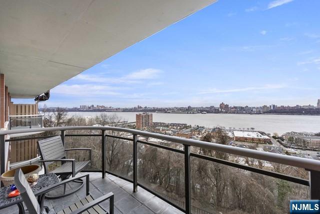 balcony with a water view and a city view