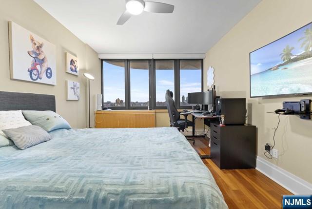 bedroom with baseboards, ceiling fan, and wood finished floors