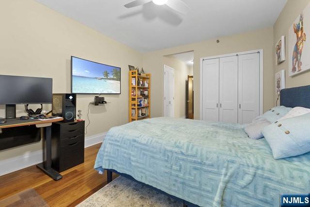bedroom featuring a closet, a ceiling fan, baseboards, and wood finished floors