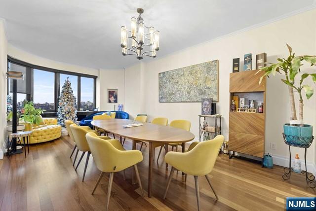 dining space featuring wood finished floors and a notable chandelier