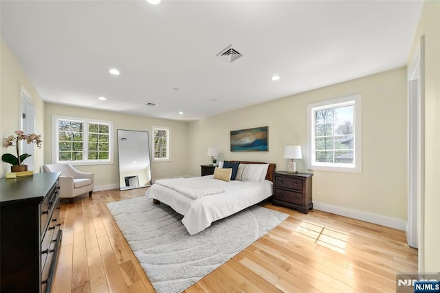 bedroom with baseboards, recessed lighting, light wood-style flooring, and visible vents