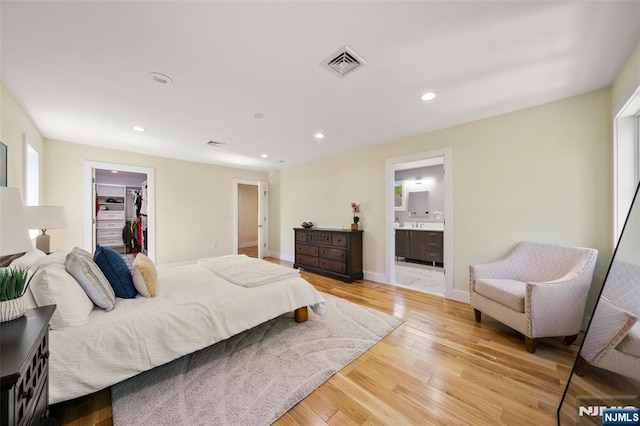 bedroom featuring visible vents, a closet, a spacious closet, recessed lighting, and light wood-style flooring