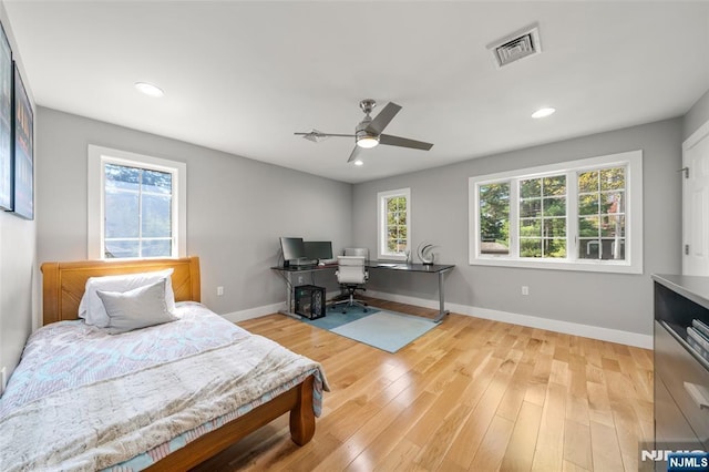 bedroom featuring visible vents, baseboards, and multiple windows
