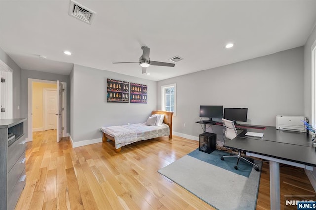 office space featuring visible vents, light wood-style floors, ceiling fan, and baseboards