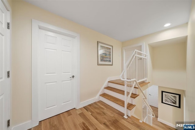 staircase featuring recessed lighting, baseboards, and wood finished floors