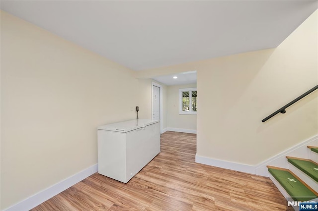 empty room with baseboards, recessed lighting, and light wood-style flooring