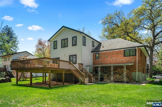 back of property featuring stairway, a deck, brick siding, and a lawn