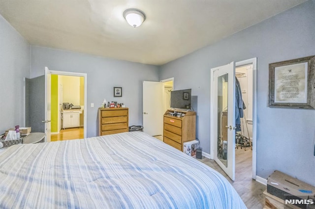 bedroom featuring baseboards and ensuite bath