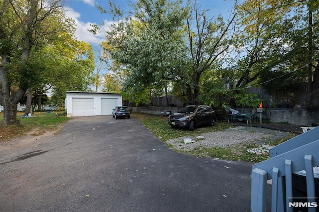 view of yard with an outdoor structure, fence, and a detached garage