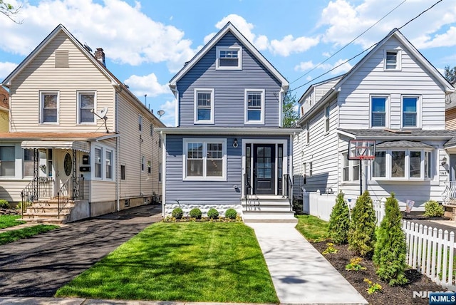 165 Jerome Pl, Bloomfield, NJ 07003 - view of front of house featuring fence, a chimney, entry steps, and a front lawn