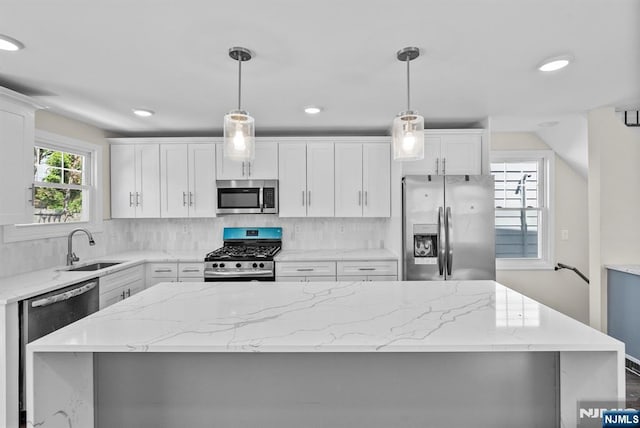 165 Jerome Pl, Bloomfield, NJ 07003 - kitchen featuring appliances with stainless steel finishes, a sink, white cabinetry, decorative backsplash, and a kitchen island
