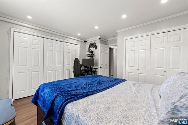 bedroom with recessed lighting, ornamental molding, multiple closets, and wood finished floors