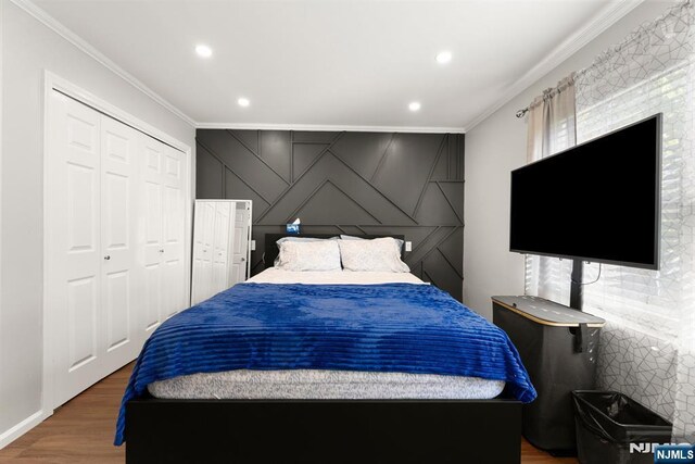 bedroom with crown molding, recessed lighting, wood finished floors, and a closet