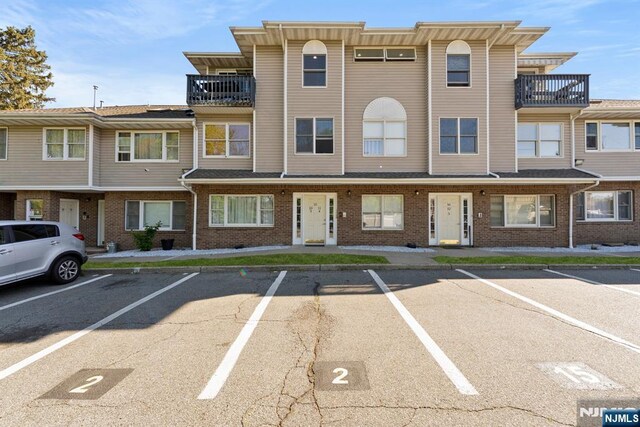 view of front of home featuring brick siding and uncovered parking
