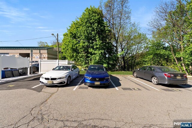 uncovered parking lot featuring fence