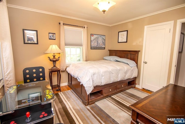 bedroom featuring ornamental molding, baseboards, and wood finished floors