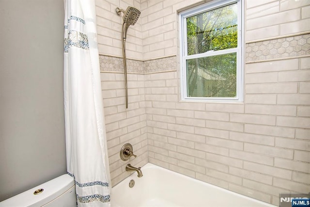 full bathroom with toilet and shower / bath combo with shower curtain