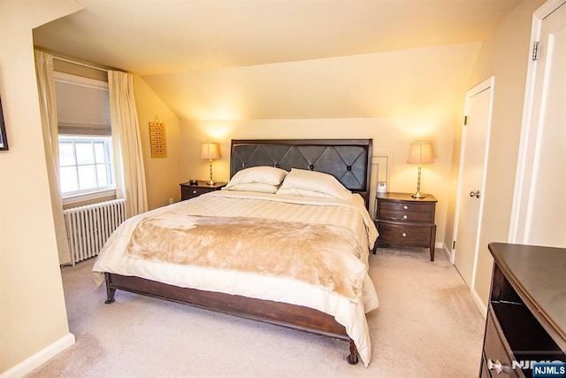 bedroom with baseboards, radiator, light carpet, and lofted ceiling