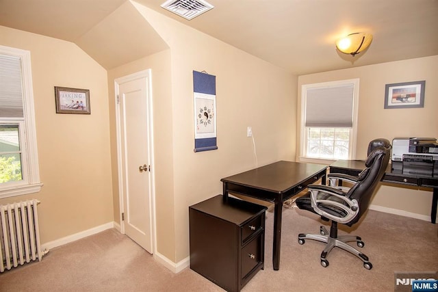 office area featuring light carpet, plenty of natural light, visible vents, and radiator heating unit