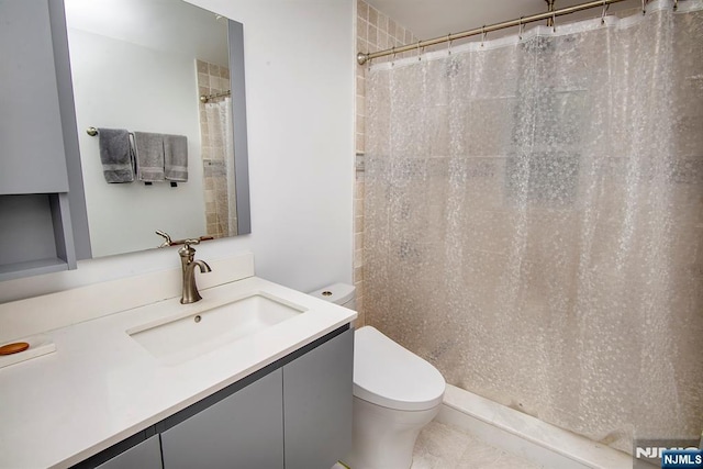 bathroom featuring curtained shower, vanity, and toilet