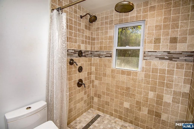 full bathroom with toilet and tiled shower