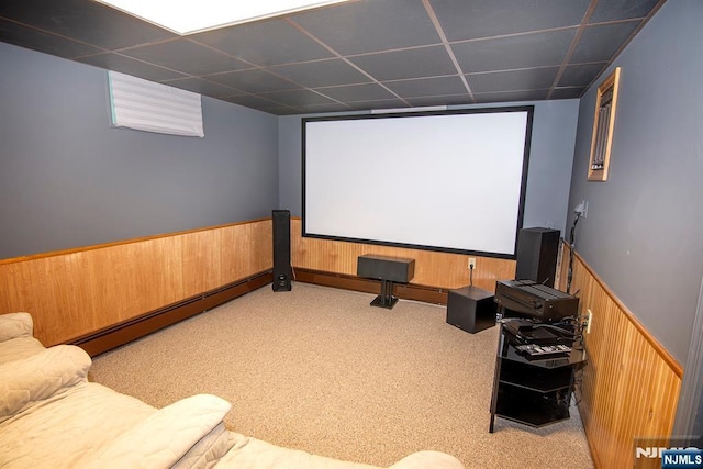 carpeted home theater room featuring wainscoting, wood walls, a paneled ceiling, and baseboard heating
