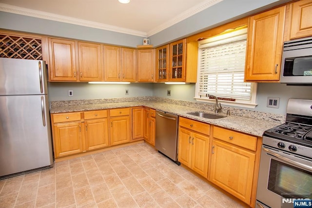 kitchen with a sink, ornamental molding, light stone counters, glass insert cabinets, and appliances with stainless steel finishes