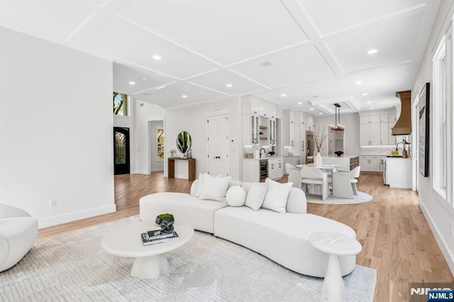 living area with recessed lighting, baseboards, light wood finished floors, and coffered ceiling