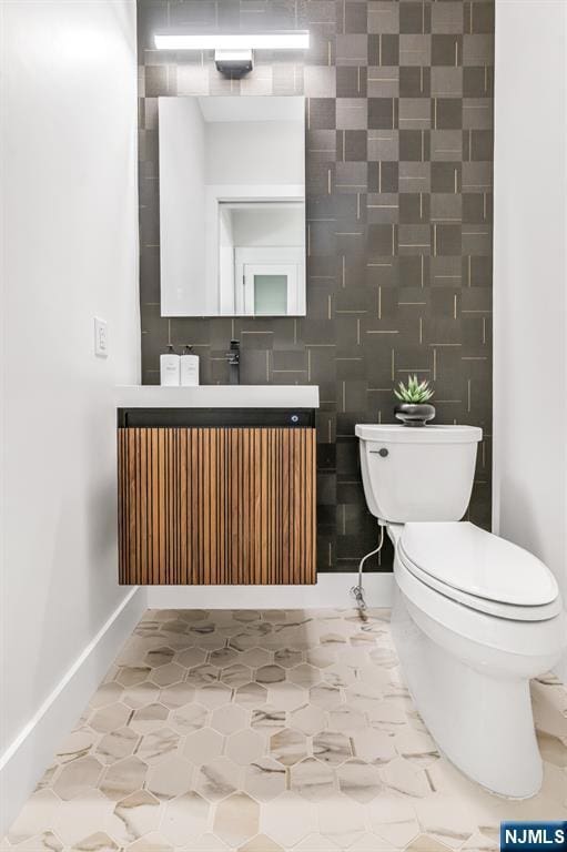 bathroom with vanity, baseboards, and toilet