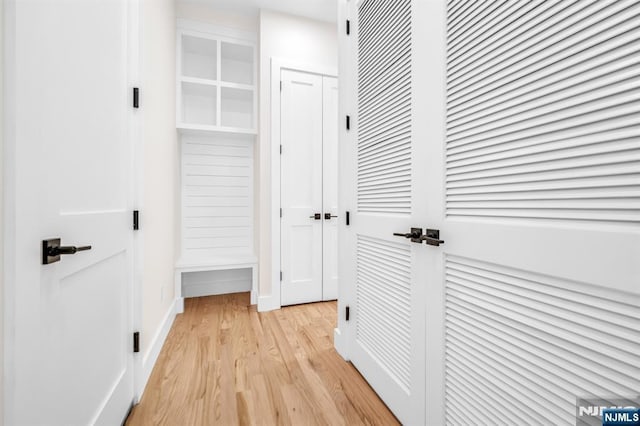 corridor featuring baseboards and light wood-type flooring