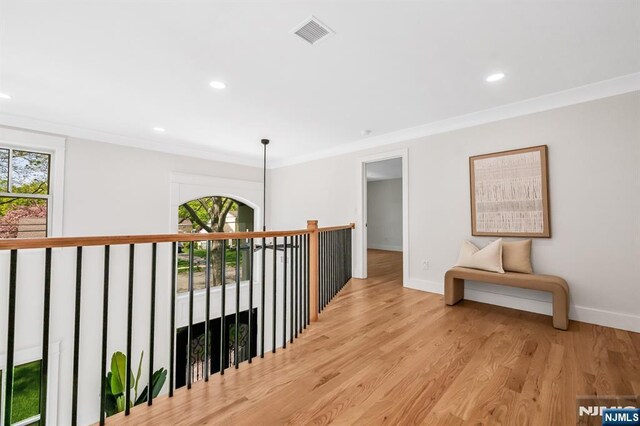corridor featuring visible vents, ornamental molding, plenty of natural light, and recessed lighting