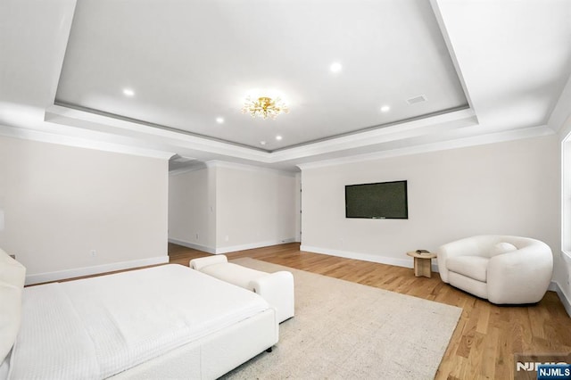 bedroom featuring crown molding, baseboards, light wood-type flooring, recessed lighting, and a tray ceiling