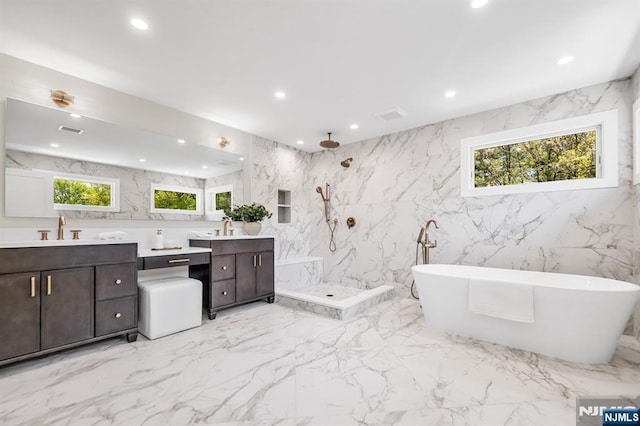 bathroom with visible vents, vanity, marble finish floor, a marble finish shower, and a soaking tub